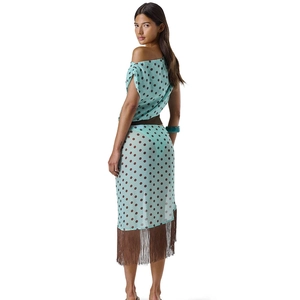 Detailed view of polka dot print on sheer fabric with long fringe hem and side slit