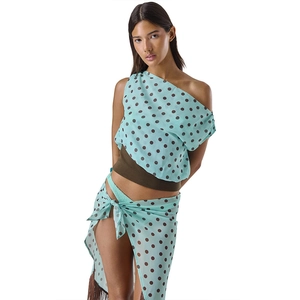 Detail of light blue polka dot top with tassel skirt featuring mesh fabric texture