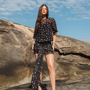 Detail view of stylish polka dot mesh top and skirt set with flowing decorative ribbon