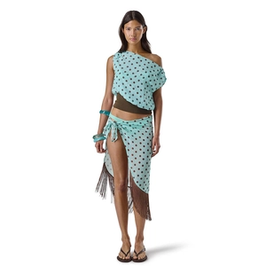 Detail of light blue polka dot one-shoulder top and fringed skirt for beach vacations