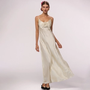 Λεπτομέρεια από ένα boho μάξι φόρεμα σε ιβουάρ με πουά και διακοσμητικό 3D λουλούδι στο στήθος