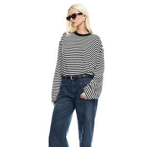 Detail view of a striped long sleeve t-shirt paired with blue denim jeans and belt