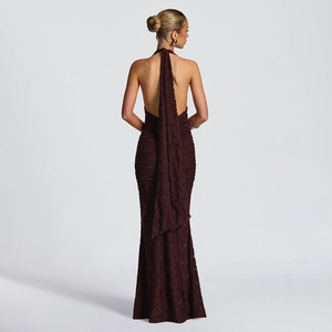 Detail view of the backless dark red halter dress featuring textured fabric and long ties