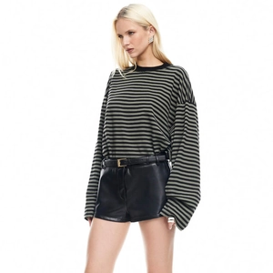 Detail of black and green striped long sleeve top with cotton knit texture and loose cuffs