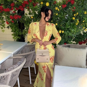 Floral yellow chiffon V-neck dress with long sleeves and high slit in a summer garden