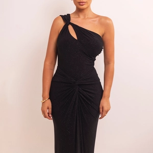 Détail de robe noire à une épaule montrant le tissu scintillant et le nœud à la taille