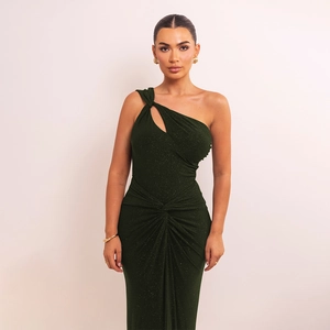 Détail d'une robe asymétrique vert foncé montrant les paillettes et le nœud à la taille