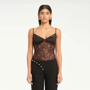 Close-up of exquisite black lace hollow-out details and satin splicing on a camisole