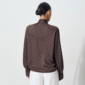 Rear view of brown polka dot blouse showing high-quality satin texture and tailored fit