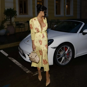 Detail of deep V-neck and waist tie on yellow floral chiffon midi dress with split hem