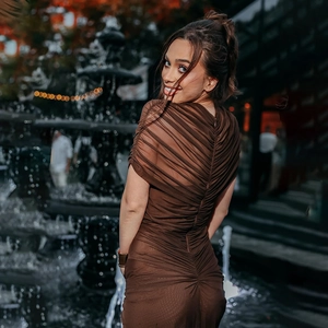 Close-up of ruched mesh texture and back drawstring detail on dark brown bodycon dress