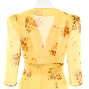 Detail view of the deep V-back design and elastic waist on yellow floral chiffon dress