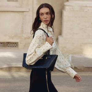 Elegant white polka dot long sleeve blouse with tie-neck and black handbag for women