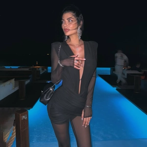 Close-up of sexy deep V-neck black bodysuit with mesh sleeves and ruched hip detail
