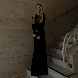 Detail of elegant black long sleeve backless maxi dress showing slim fit silhouette