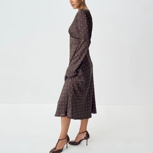 Detail of brown polka dot satin midi dress featuring elegant black lace trim and long sleeves