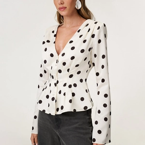 Polka dot V-neck long sleeve blouse with waist-defining peplum hem and button-front detail