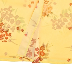 Detailed macro view of yellow floral chiffon fabric with side slit and fine stitching