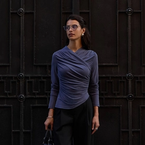 Detail view of slim fit long sleeve top with irregular hem and side ruched draping