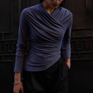 Detailed view of long sleeve ruched top with elegant cross V-neck and slim fit texture