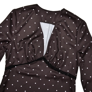 Close-up of elegant V-neckline with black lace trim and white polka dot satin fabric