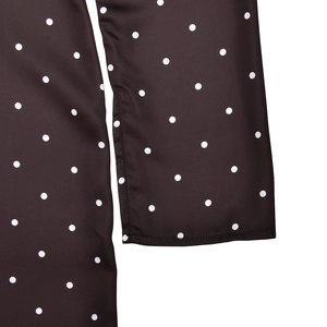 Detailed macro shot of white polka dots on premium black satin fabric with fine stitching