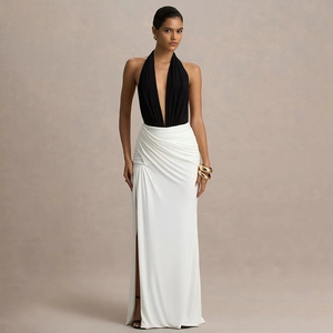 Détail de robe dos nu à col en V profond avec corsage noir et jupe blanche fendue