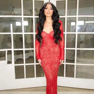 Detail of red floral lace dress featuring a deep V-neck and sheer long sleeves