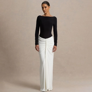Vue détaillée de l'élégante jupe blanche froncée et du corsage noir ajusté à manches longues