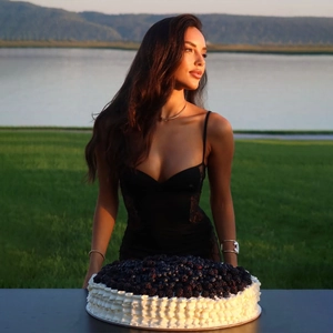 Détail d'un collier clou doré élégant porté avec une robe en dentelle noire au bord du lac