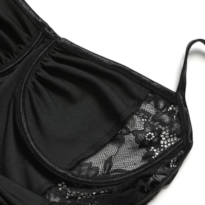 Vue macro d'une délicate broderie en dentelle noire et texture mesh sur le corsage
