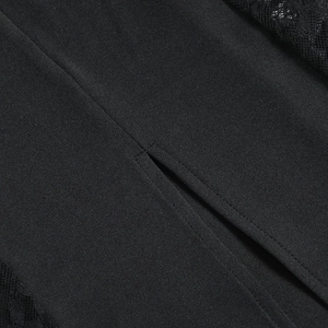 Gros plan sur les coutures de dentelle noire et la fente en tissu tissé de la robe