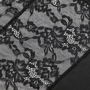 Vue détaillée de la dentelle florale noire et des coutures sur une robe moulante