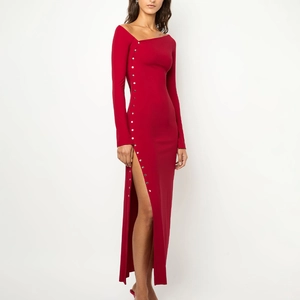 Détail de la fente latérale haute sur robe maxi rouge cintrée avec boutons métalliques