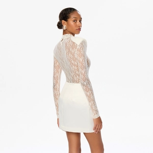 Close-up of white semi-transparent floral lace top with shoulder pads and elegant satin skirt