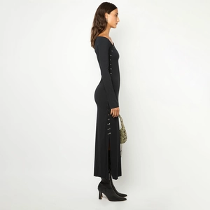 Détail des boutons en métal et de la fente latérale sur une robe noire moulante