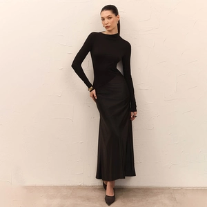 Detail of elegant black long sleeve top paired with a flowing silk satin maxi skirt