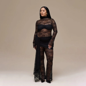 Detail view of black lace jumpsuit with hollow-out pattern and layered ruched design