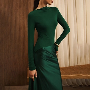 Detail of elegant dark green dress showing matte high neck top and satin fabric texture
