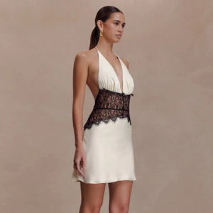 Elegant white satin halter mini dress with black lace waist detail and deep V-neckline