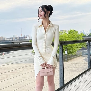Detail of a slim fit cream polo dress with button-down front and asymmetric slit hemline