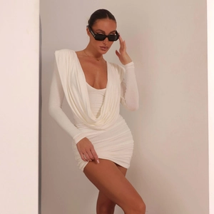 Detail of white long sleeve dress with deep V-neckline and elegant draped front design