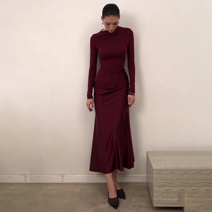 Detail shot of a slim-fit burgundy long-sleeved dress with elegant satin luster fabric