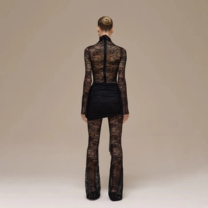 Back view of a slim fit black lace bodysuit featuring floral patterns and flared trousers
