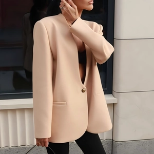 Detail of elegant beige slim blazer featuring a single metallic button and premium fabric
