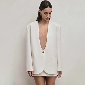 Detail of white slim-fit blazer with deep V-neck, padded shoulders and single button