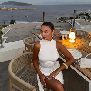 Détail de robe blanche moulante avec col montant sans manches sur une terrasse de mer