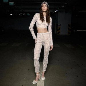 Detail of silver sequin two-piece set featuring long sleeves and high waisted pants