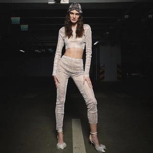Close-up of sparkling sequin fabric on a long-sleeve crop top and matching slim pants