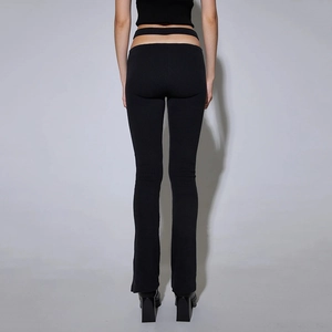 Detailed view of black ribbed knit flared trousers featuring sexy waist cut-out design